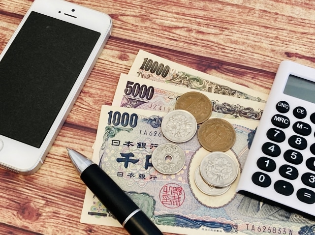 Banknotes, smartphone and calculator